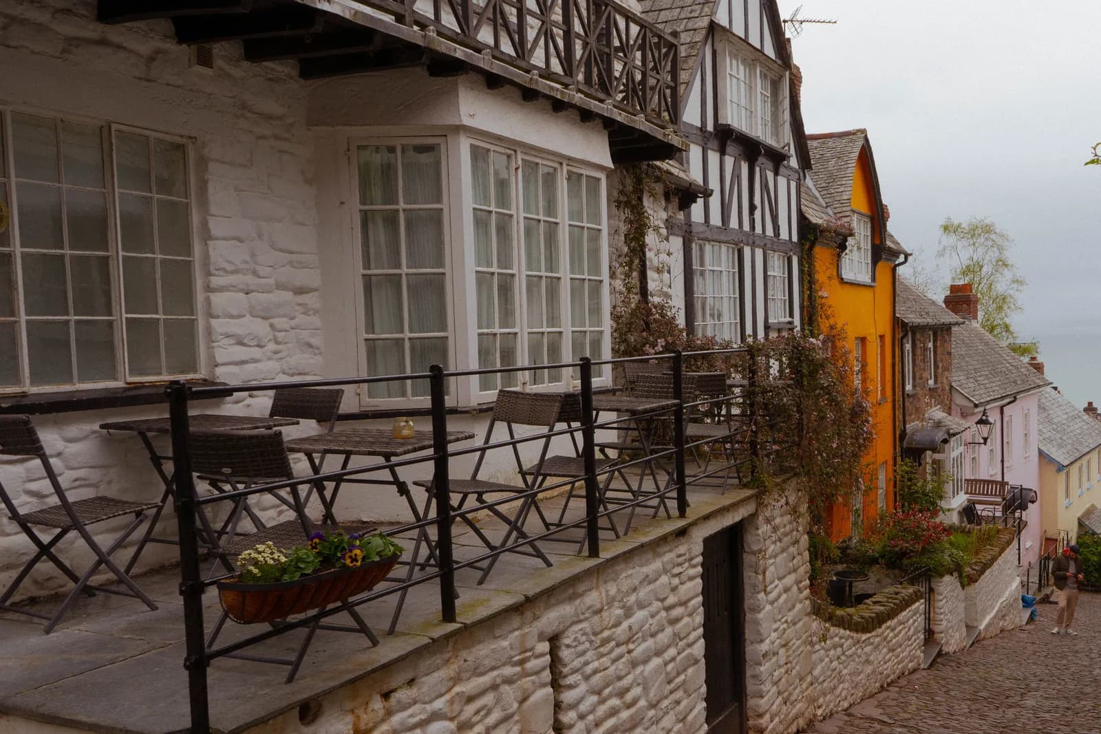 A steep cobbled street of whitewashed cottages in a North Devon coastal village on an overcast day