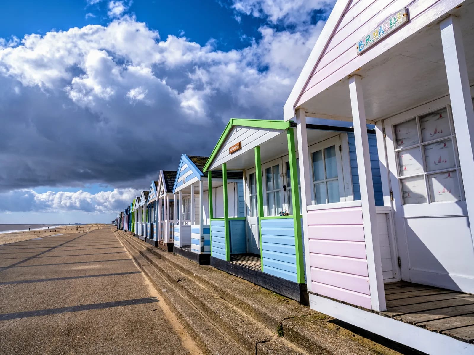 A row of colourful beach huts along the promenade at Southwold on the Suffolk coast